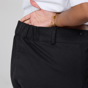 Closeup of elasticated back waistband of the black twill trousers.