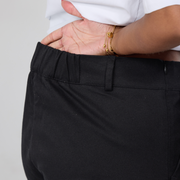 Closeup of elasticated back waistband of the black twill trousers. 