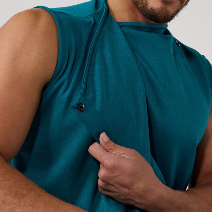 Close up of a teal coloured top that wraps at the front neck with a black snap fastening.