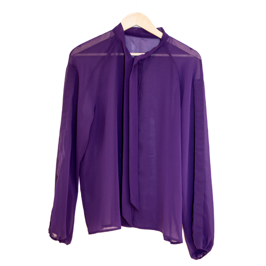 Purple chiffon shirt with front tie undone against white.