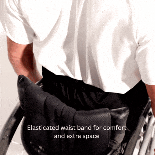 Video of a male model in a manual wheelchair, adjusting the elasticated waistband of the twill trousers to display its flexibility and ease of comfort.