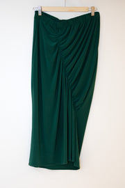 Ruched skirt in forest green hanging on a wooden clip hanger against a white background